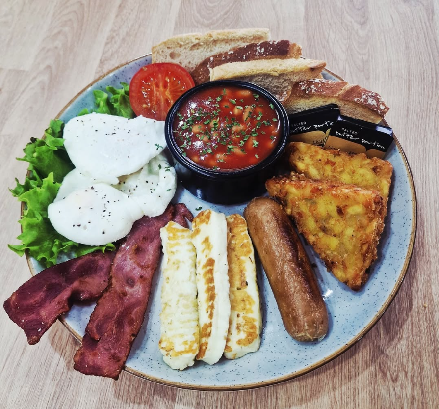 House English breakfast platter — poached eggs, turkey bacon, halloumi, sausage, hash browns, beans and toast at Cristina's Cafe Romford